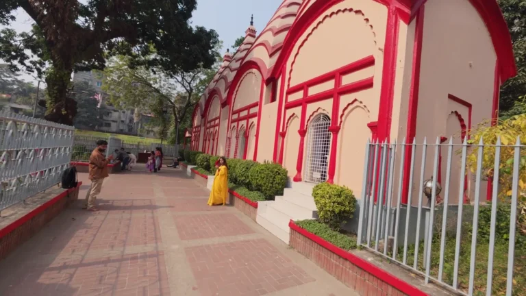 Red and cream heritage building beside a pavement in Dhaka, Bangladesh