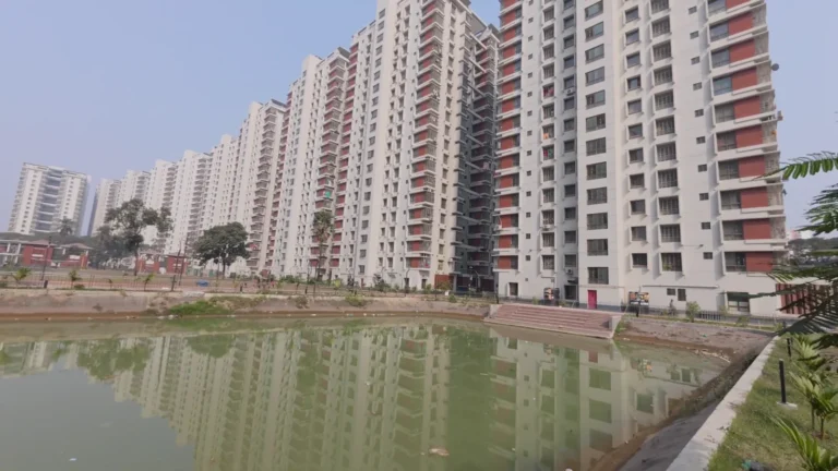 High-rise apartment blocks around a green pond in Dhaka, Bangladesh