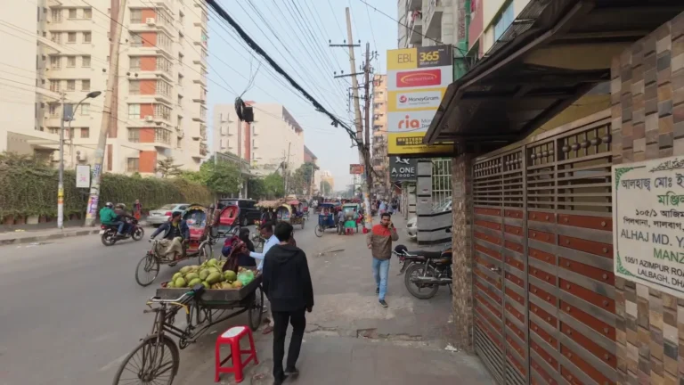 Busy street with shops and overhead wires in Dhaka, Bangladesh