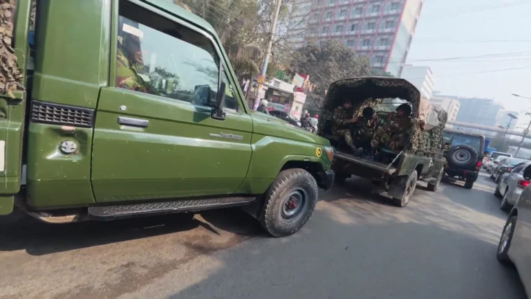 Green trucks on a city street in Dhaka, Bangladesh
