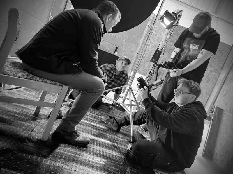 Andy Blithe on set with the camera crew, black and white