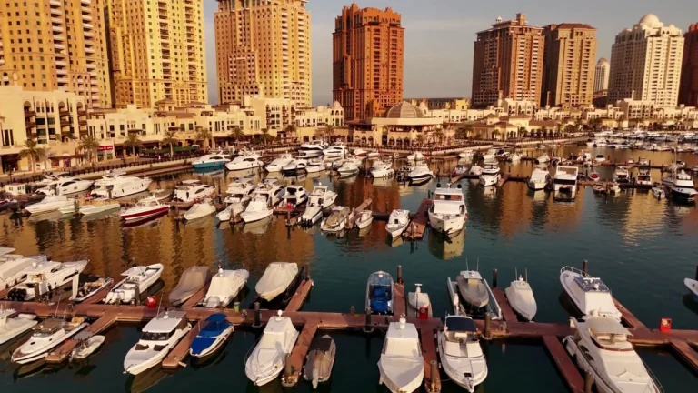 Marina full of boats in front of apartment towers in Qatar