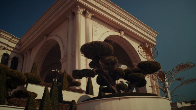 Ornate arched building and sculpted trees in Qatar