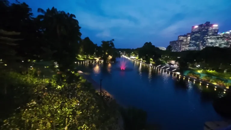 Waterway lined with trees and lights at night in Singapore