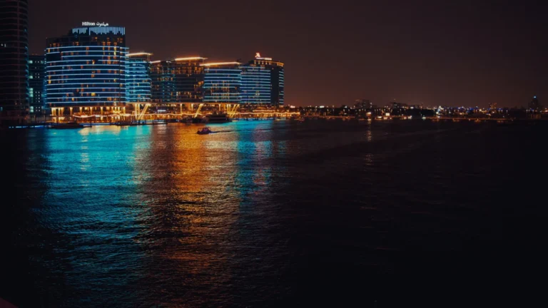Hotel lights reflected in the water at night in Dubai, UAE